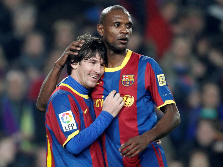 Former Barcelona defender Eric Abidal embraces teammate Lionel Messi during a past match