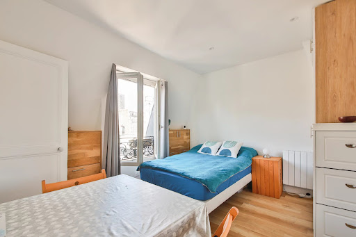 Bedroom with blue bed and table in this luxury apartment / penthouse for sale in Paris 17ème ($262,752 - 16 m²)