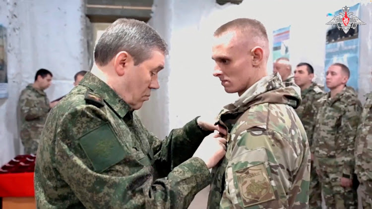 Chief of the General Staff of Russian Armed Forces Valery Gerasimov presents an award to a serviceman during a meeting with military personnel who, according to the Defence Ministry, participated in taking Avdiivka, at a Russian military command centre in a location given as Russian-controlled Ukraine, in this still image taken from video released February 21, 2024.