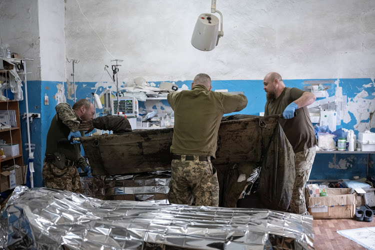 Medics place a wounded Ukrainian soldier on a table in the operation room of a frontline medical stabilisation point amid Russia’s attack on Ukraine, near Vuhledar, Donetsk region, Ukraine, on February 19 2023. Picture: REUTERS/