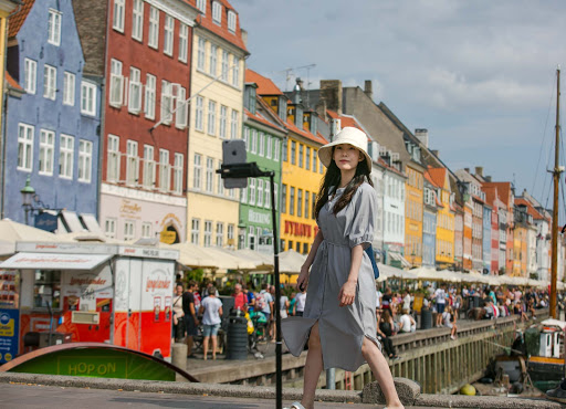 podcaster-in-nyhavn.jpg - A foreign podcaster live-streams with Nyhavn as the backdrop in Copenhagen. 