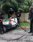 City Power officials remove its cables which were found at a house in Lombardy. Police want to speak to the owner of the house, who was not available during the visit on Saturday.