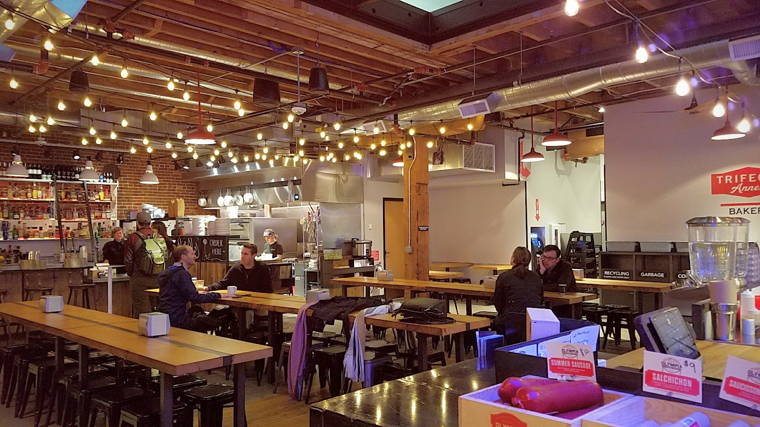 The central communal seating area inside Pine Street Market, a food hall in downtown Portland with nine vendors is more relaxing during the Pine Street Market Brunch time daily 9-11 AM