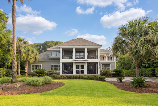 Luxury house for sale in Kiawah Island (United States) - Gray house with green lawn and palm trees
