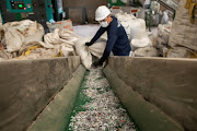 A worker loads shredded plastic to a machine to be molded into waterproof planks in the factory of social enterprise The Plastic Flamingo or The Plaf, in Muntinlupa, Philippines, October 18, 2021. The Plaf gathers plastics from restaurants, companies, and consumers and transforms them into useable raw material like waterproof planks.  