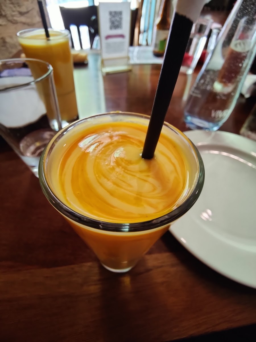 Slender glass of thick mango lassi. Not too sweet.