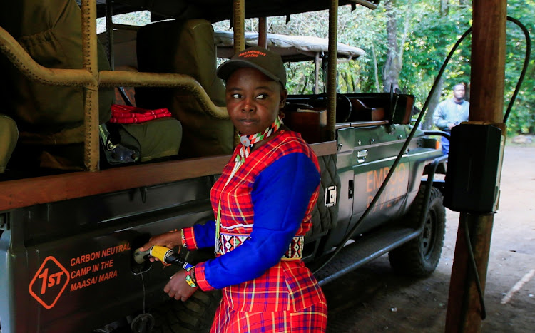 Gladys Kisemei, a tour guide at the Emboo River Camp connects an electric-powered safari vehicle to the charging system after a game drive at the Maasai Mara National Reserve in Narok County, Kenya July 16, 2021.