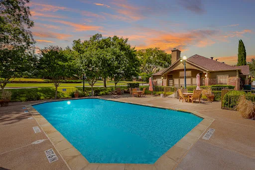Wellington Place community pool with view of clubhouse in the background at dusk