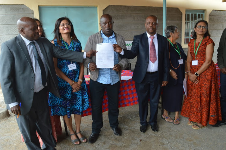 Amara NGO officials with Empakasi Secondary School infrastructure committee chairman Jeremiah Kaloi during the commissioning of newly constructed dormitories, kitchen and dining hall at the school in Athi River North, Machakos on Monday, January 24.