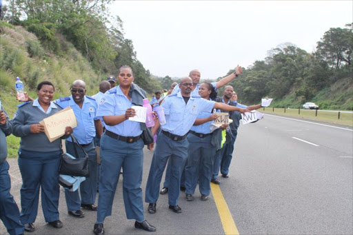 CATCHING A HIKE: Traffic officials from the Wilsonia traffic station hitching a hike home after being told they can't take work cars home. Picture: SILUSAPHO NYANDA