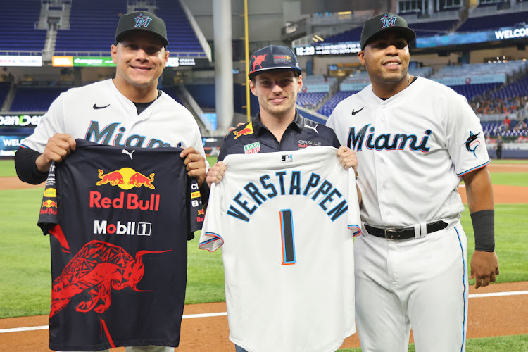 Avisail Garcia, left, and Jesus Aguilar, right, of the Miami Marlins pose for a photo with F1 driver Max Verstappen before the game against the Arizona Diamondbacks at LoanDepot Park on May 4 2022 in Miami, Florida.