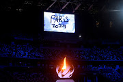 The Olympic torch and cauldron are seen with Paris 2024 displayed on the big screen during the closing ceremony.