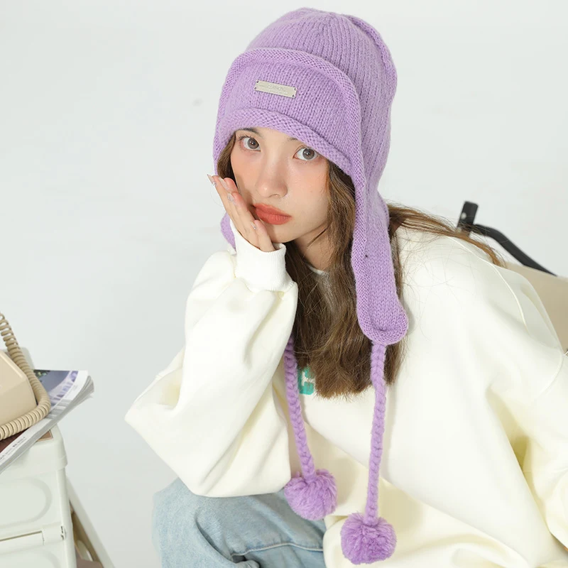 Cappello da donna con protezione per le orecchie e gomitolo di lana lavorato a maglia