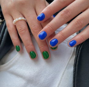 A close up of a person's hands with blue and green painted nails

Description automatically generated
