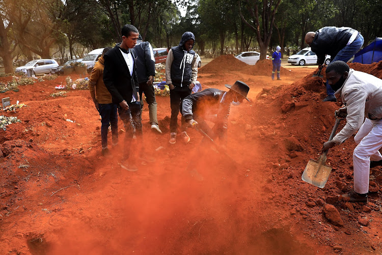 Friends and family help bury Osvaldo Minegen, 11, at the West Park Cemetery in Johannesburg on Friday, August 7. Minegen was struck and killed by a car on the last day of July.