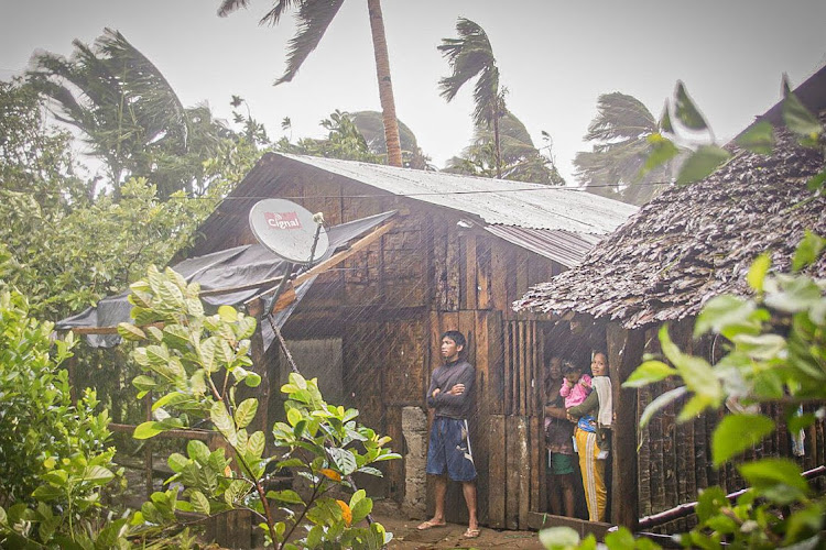 Residents take shelter as they observe rain and wind in Can-avid town in the central Philippines on Thursday as Typhoon Vongfong makes landfall.