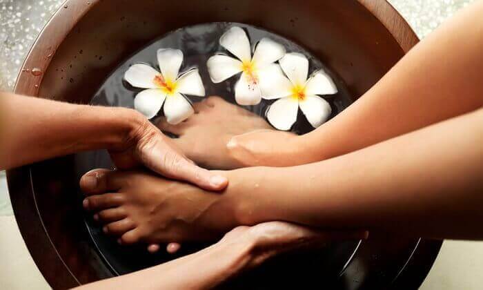 Bàn chân được ngâm trong nước thảo mộc ấm trong buổi massage chân tại Herbal Spa Đà Nẵng