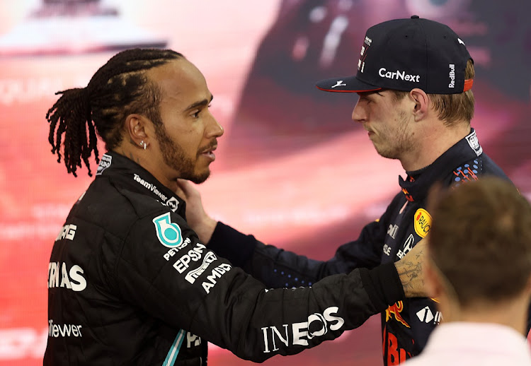 Race winner and 2021 F1 World Drivers Champion Max Verstappen of Netherlands and Red Bull Racing is congratulated by runner up in the race and championship Lewis Hamilton.