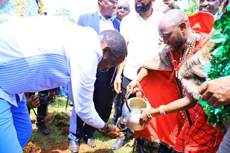 Media Personality Stephen helps Narok Governor Patrick Ole Ntutu wash his hands during his Thanksgiving ceremony at Enooretet Village in Narok County on October 13, 2023.