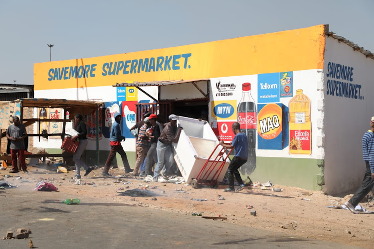 Residents of Jabavu, Soweto, loot a foreign-owned spaza shop after Banele Qhayiso was allegedly shot dead by a shop owner on August 29, 2018.