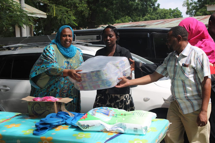 Mombasa Women's Empowerment Network chair Amina Abdalla donates supplies at the Port Reitz Mental Clinic in Changamwe on Monday.