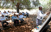 Jacob Rapudi, a teacher at Makangwane Secondary School, conducts lessons under a tree. The writer says children and youths still have to run from the hardships visited upon them under the democratic government.