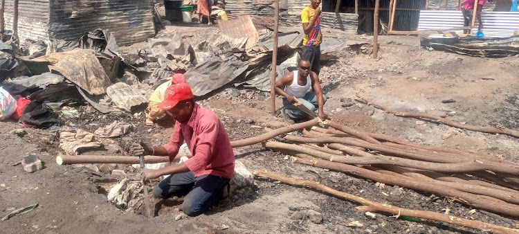 Carpenters busy reconstructing stalls at the Garissa market that was razed down on Thursday, June 23.