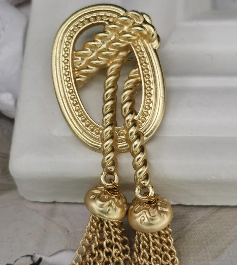 Broche rétro or mat baroque à pendre avec gland en corde de chanvre tressée pour femme. Élégance vintage et sophistication assurées