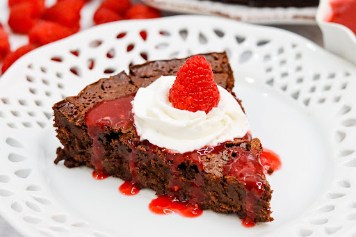 A slice of Dark Chocolate Torte with raspberry coulis.