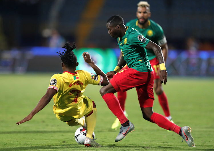 Cameroon's Ambroise Oyongo in action with Benin's David Djigla