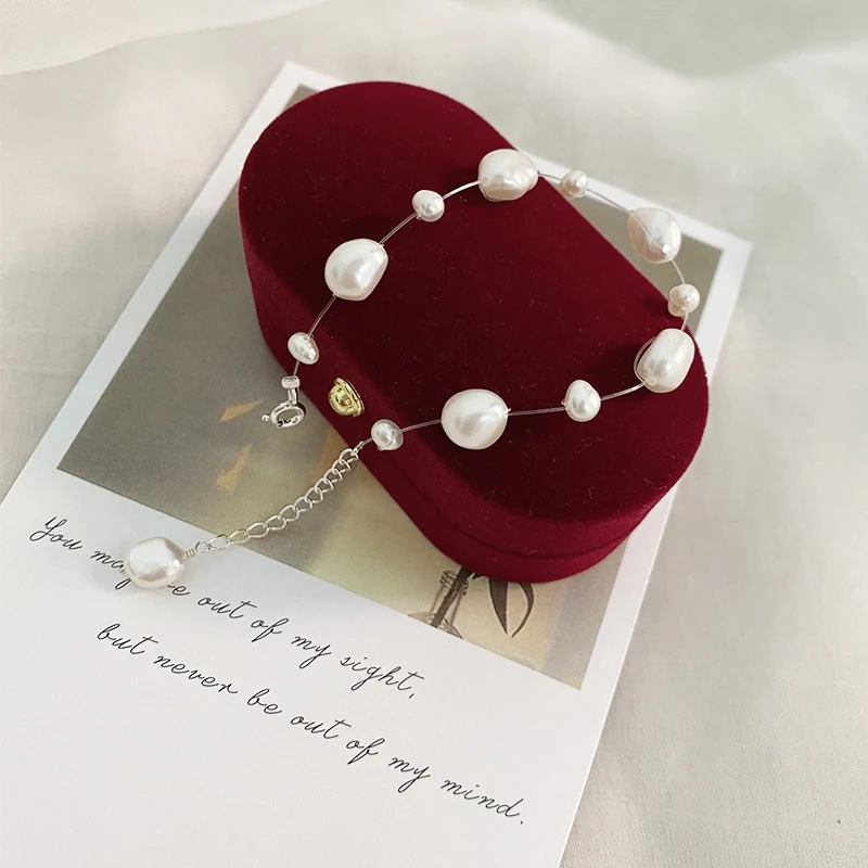 Transparante viszijde armband met natuurlijke barok parel. Uniek en elegant ontwerp voor een vleugje natuurlijke schoonheid en tijdloze uitstraling.