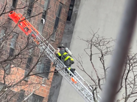 A baby is rescued as personnel from the New York City Fire Department (FDNY) respond to an apartment building fire in the Bronx borough of New York City, US, January 9, 2022.