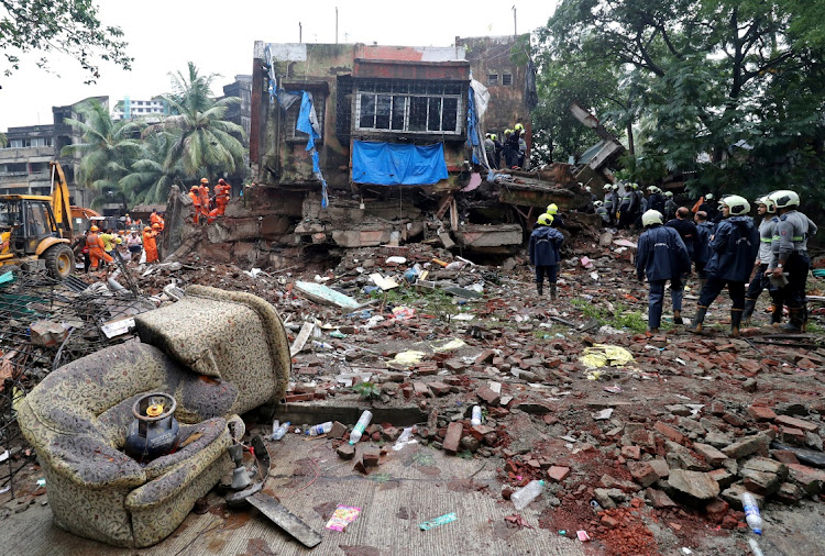 Rescue workers and firefighters search for survivors at the site of a collapsed residential building in Mumbai, India, June 28 2022.