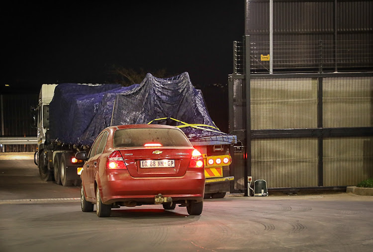 A truck carrying electrical equipment, followed by a security escort, leaves a warehouse in Midrand en route to Durban at 4am on July 17 2021.