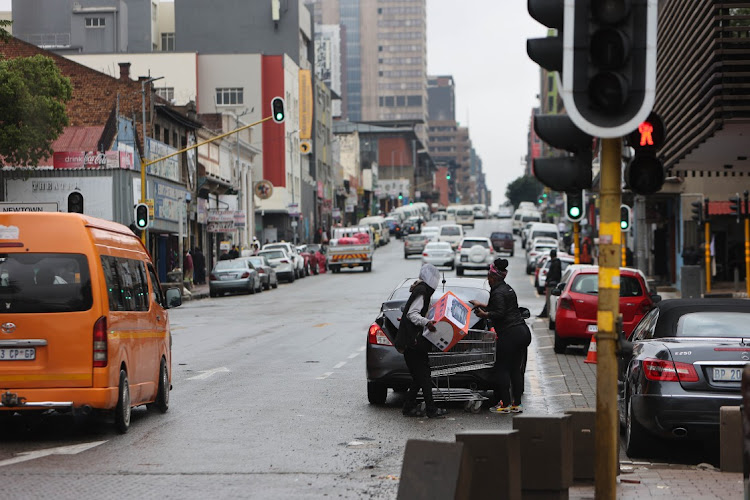 People use a break between downpours to load items into their car in Newtown on November 8 2022.