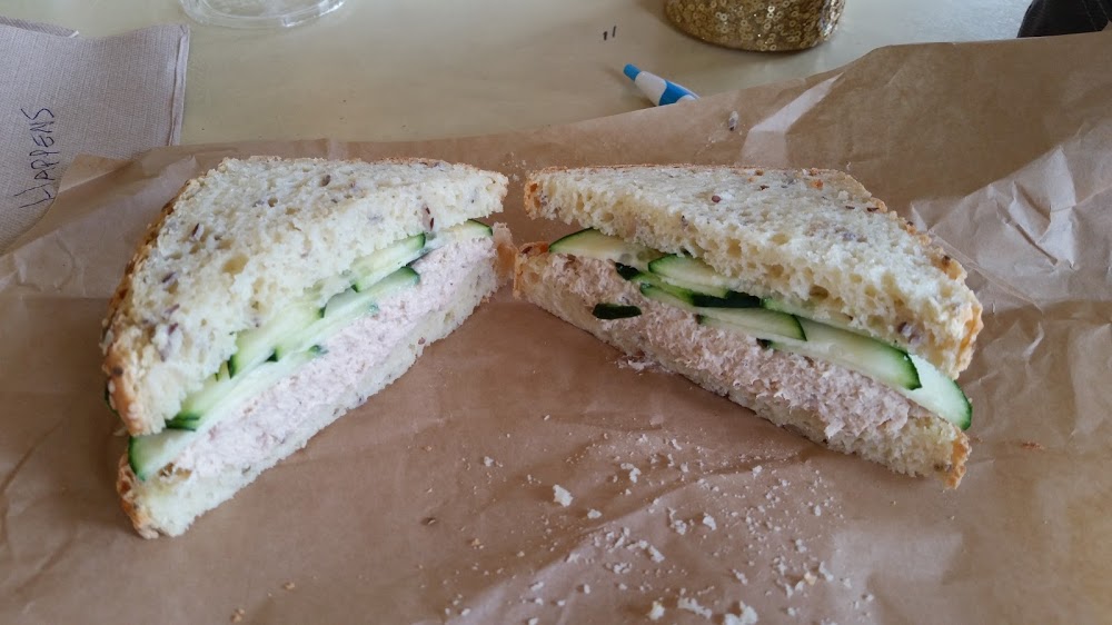 Fresh wild caught salmon salad sandwich on multi-seeded bread, topped with organic cucumber.