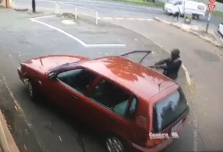 A screenshot from CCTV camera footage shows a man cocking his gun and pointing it at a 69-year-old woman in Caversham Road, Pinetown, on Monday afternoon.