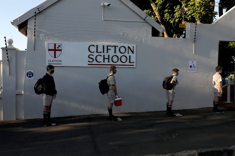 Pupils queue outside Clifton College in Durban as they wait to be disinfected.