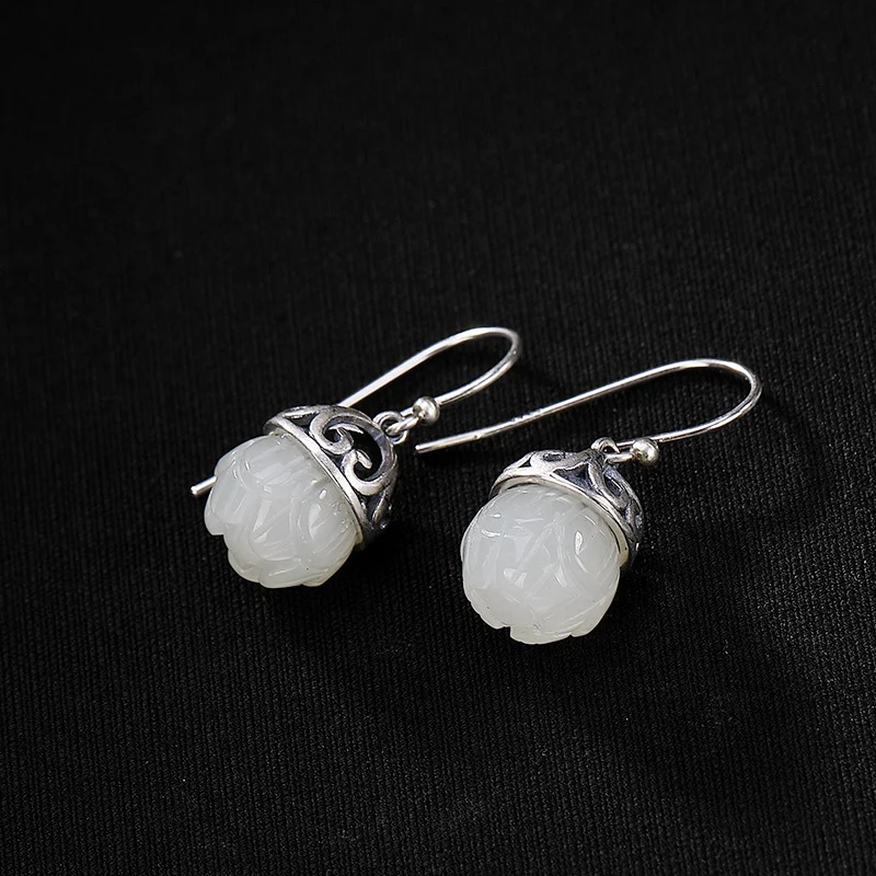 Sterling zilveren oorhangers lotusvorm met natuurlijk Hetian jade. Ervaar tijdloze elegantie en de schoonheid van deze sieraden.