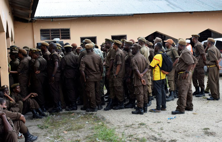 Tanzanian security officers gather at a polling centre during the early voting for essential workers at the presidential and parliamentary polls in the semi-autonomous island of Zanzibar, Tanzania, on October 27 2020.