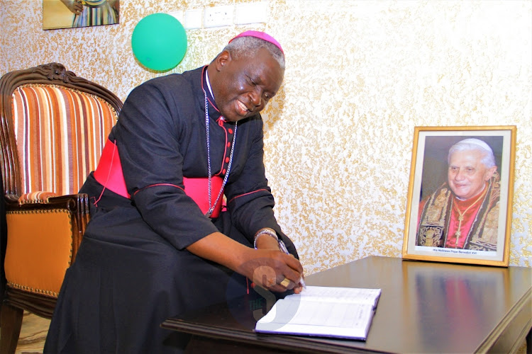 Archbishop of the Nairobi Catholic Archdiocese Philip Anyolo signs the condolence book after the mass at Holy family Basilica on December 5, 2023.