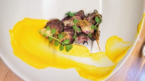 Farm Spirit, an all vegan restaurant, Brussels roasted and kraut with pinot noir vinegar, squash puree with hazelnut oil and winter cress, black garlic, pepitas paired with non alcoholic drink of Marionberry Elderflower Kefir