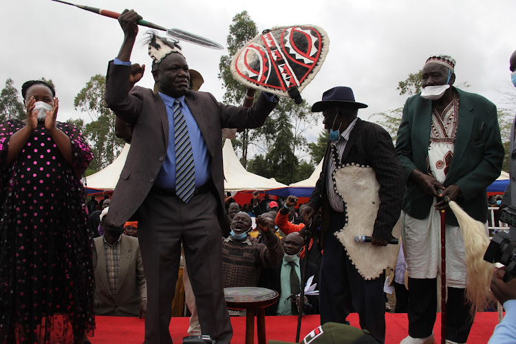 Former Kasipul MP Oyugi Magwanga with a spear and shield at Kosele stadium in Karachuonyo constituency