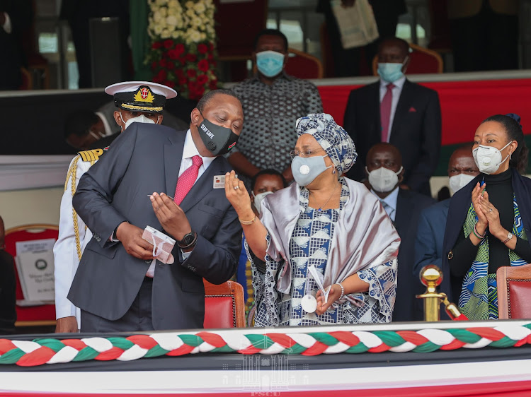 President Uhuru Kenyatta and First Lady Margaret Kenyatta look at their Huduma cards during the Mashujaa Day celebrations at the Gusii Stadium on October 20, 2020.