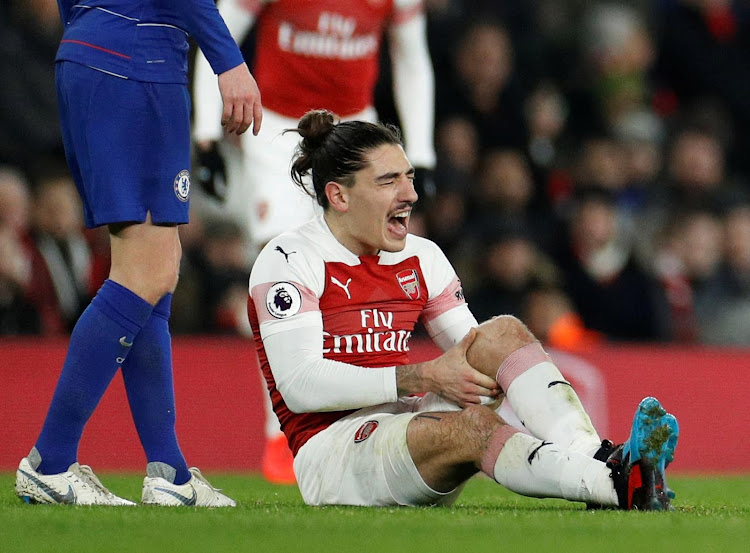 Arsenal's Hector Bellerin writhes in pain after a knee injury