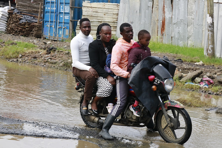 Bodaboda operator ferrying four pillion passengers maneuvers through flooded section of the newly tarmacked Kincar – Zebra – Airways road in Mavoko, Machakos County on May 6, 2024.