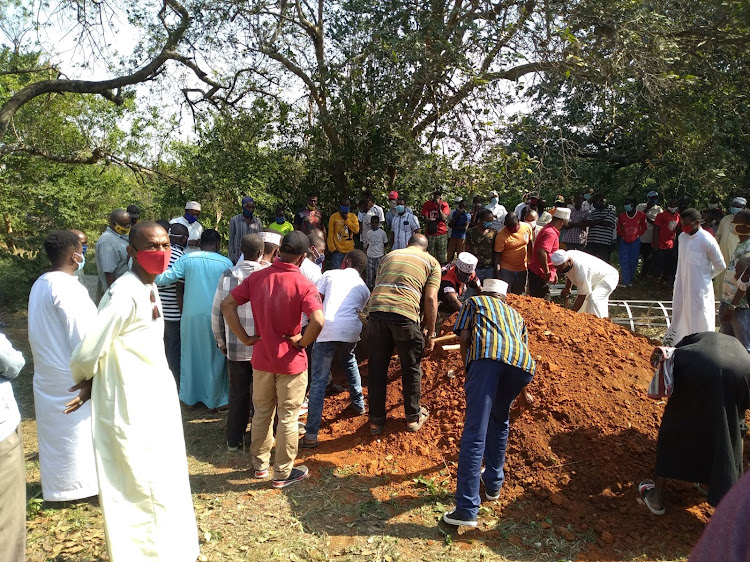 Residents help bury the body of ex-MP Ramadhan Kajembe's first wife Aziza, at the Kajembe family cemetery at Kwa Shee. Mikindani in Jomvu constituency on Friday.