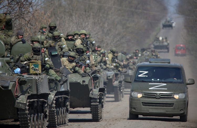 Service members of pro-Russian troops ride on armoured vehicles in the course of Ukraine-Russia conflict on a road leading to the city of Mariupol, Ukraine April 15, 2022