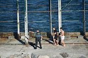 Two migrants walk after crossing the Spanish-Moroccan border in the presence of a Spanish civil guard in Ceuta, Spain, May 17, 2021. Morocco and Spain are clamping down on immigrants.
