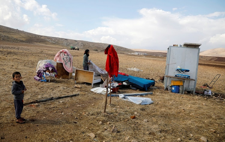 A Palestinian boy looks on as he stands near his family destroyed tented home in Khirbet Humsah in Jordan Valley in the Israeli-occupied West Bank November 5, 2020.